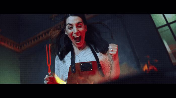 a woman in a white shirt and black apron holding a fire extinguisher