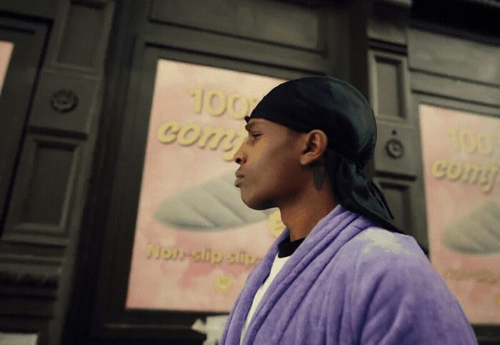 a woman in a purple robe standing in front of a building