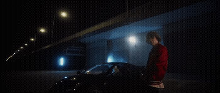 a woman standing next to a car in the dark