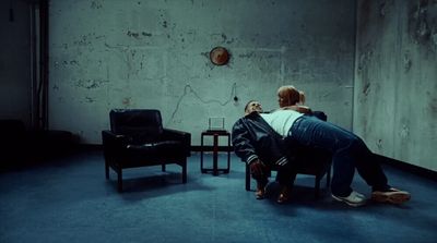 a man sitting on a chair in a dark room