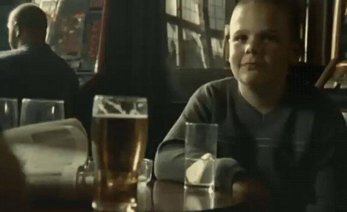 a man sitting at a table with a glass of beer