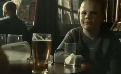 a man sitting at a table with a glass of beer