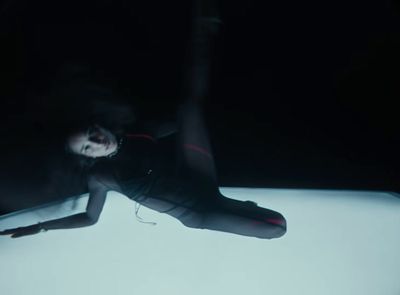 a woman is floating in the air on a white surface