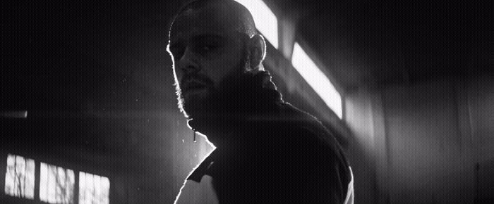 a man standing in a dark room next to a window