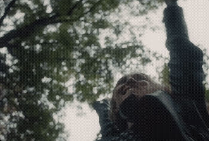 a woman standing in front of a tree