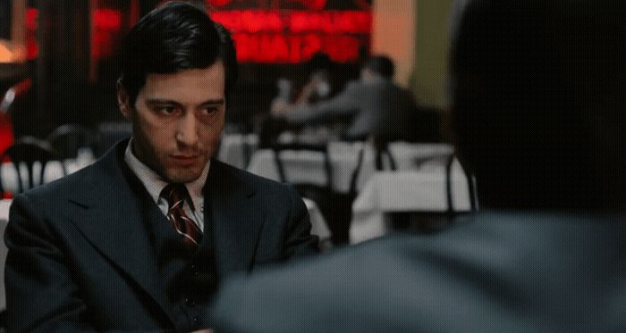 a man in a suit and tie sitting at a table