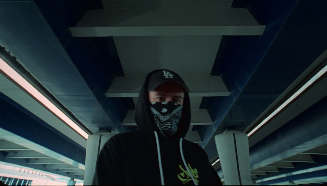 a man wearing a black hoodie and a black mask