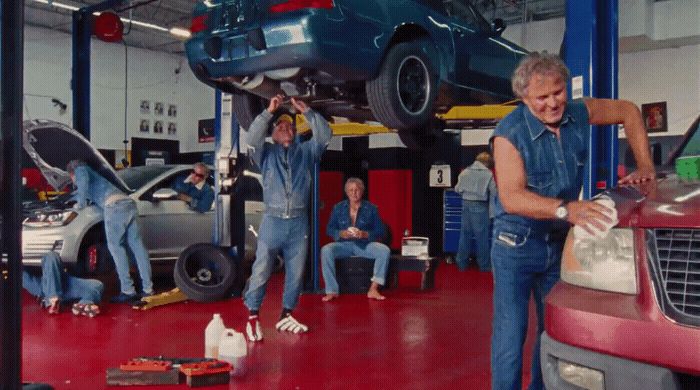 a group of men working on a car in a garage