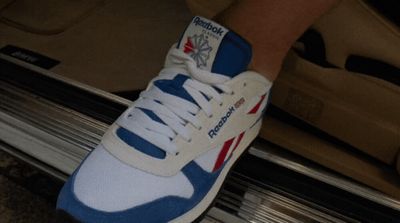 a person's foot wearing a blue and white sneaker