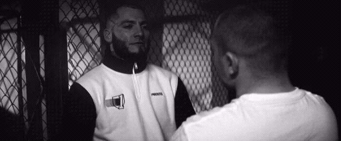 a black and white photo of a man talking to another man