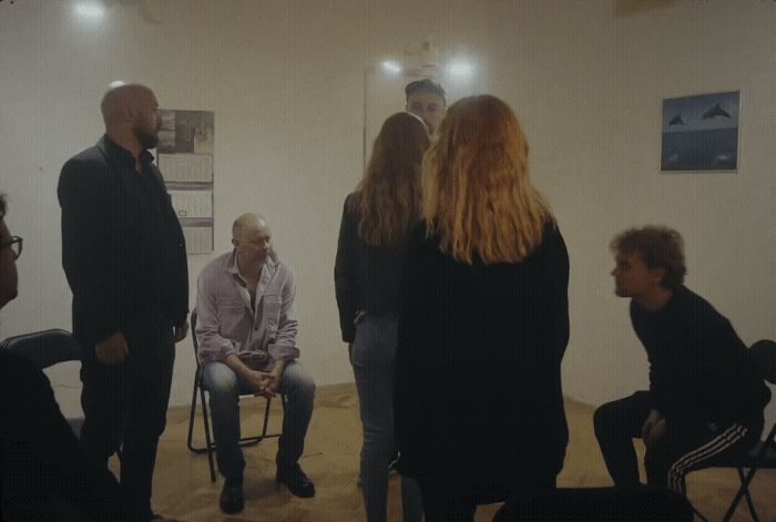 a group of people standing and sitting in a room