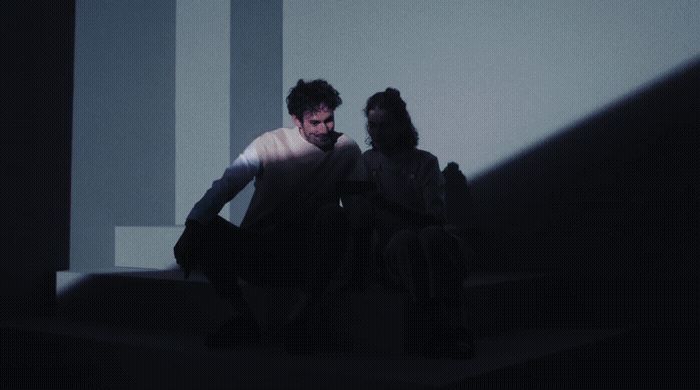 a man and a woman sitting on a step in the dark