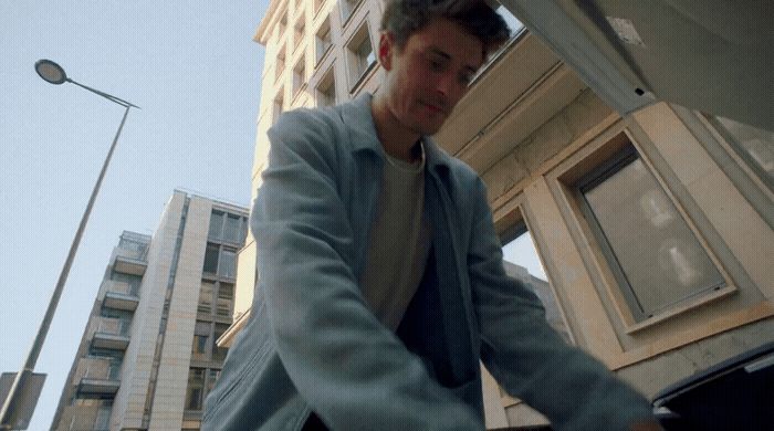 a man riding a skateboard down a street next to tall buildings