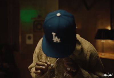 a person wearing a dodgers hat and holding a wine glass