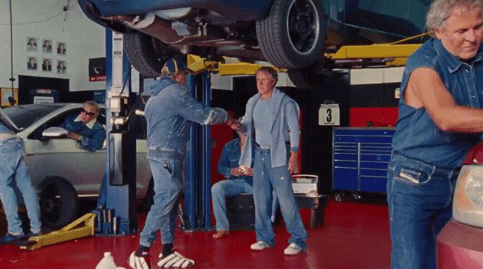 a group of men working on a car in a garage