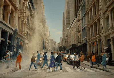 a group of people walking across a street