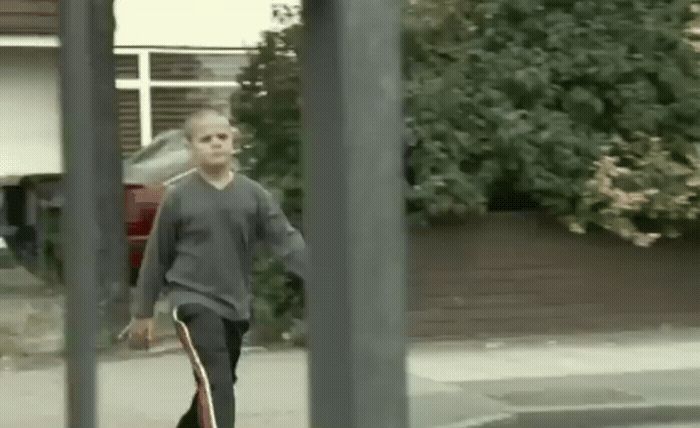 a man walking down a street holding a skateboard