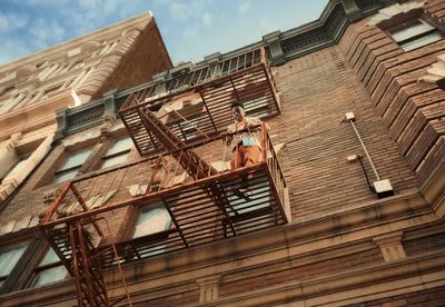 a man is standing on a ladder on the side of a building