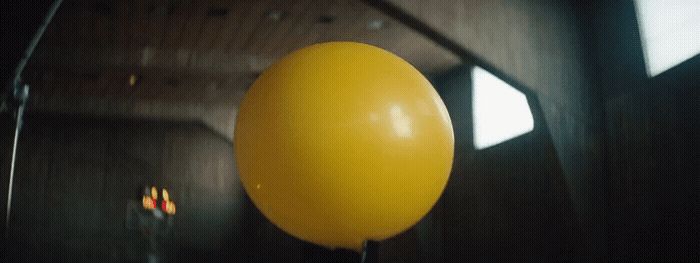 a large yellow balloon hanging from a ceiling