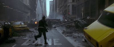 a man walking across a street next to a yellow taxi