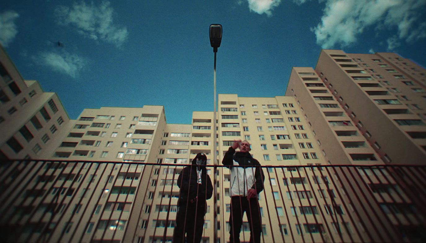 a couple of people standing next to a tall building