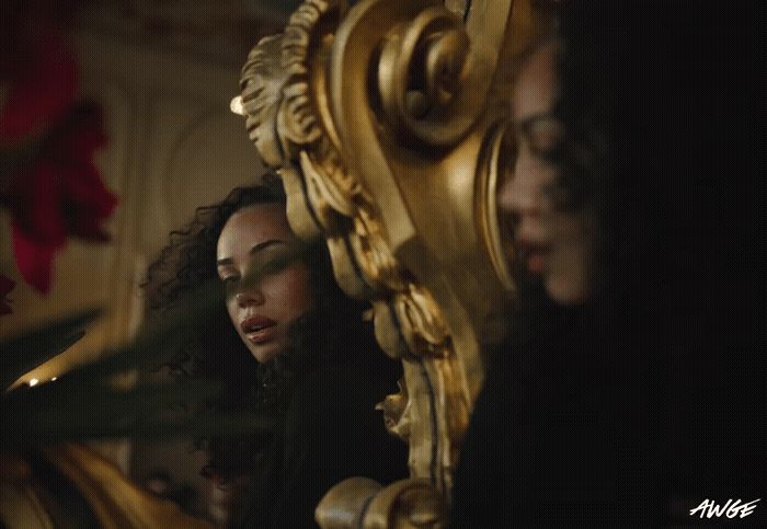 a group of women standing around a golden mirror