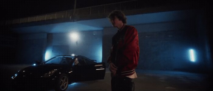 a man standing next to a car in a parking garage