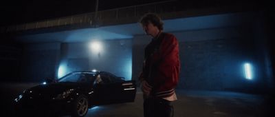 a man standing next to a car in a parking garage