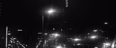 a black and white photo of a city street at night