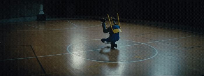 a person standing on a basketball court holding two sticks