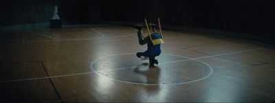 a person standing on a basketball court holding two sticks