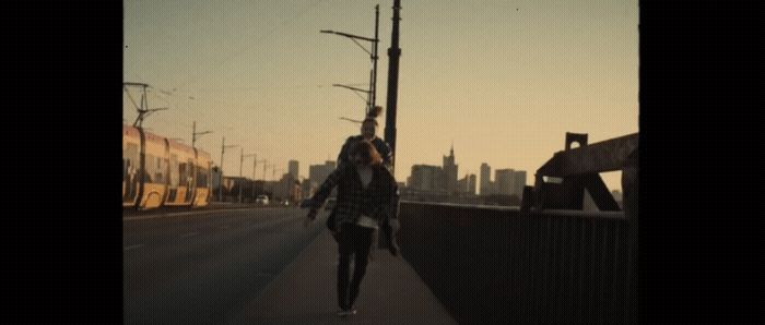 a woman walking down a sidewalk next to a train