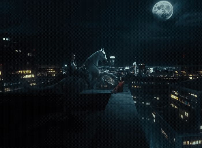 a man riding a horse on top of a roof at night