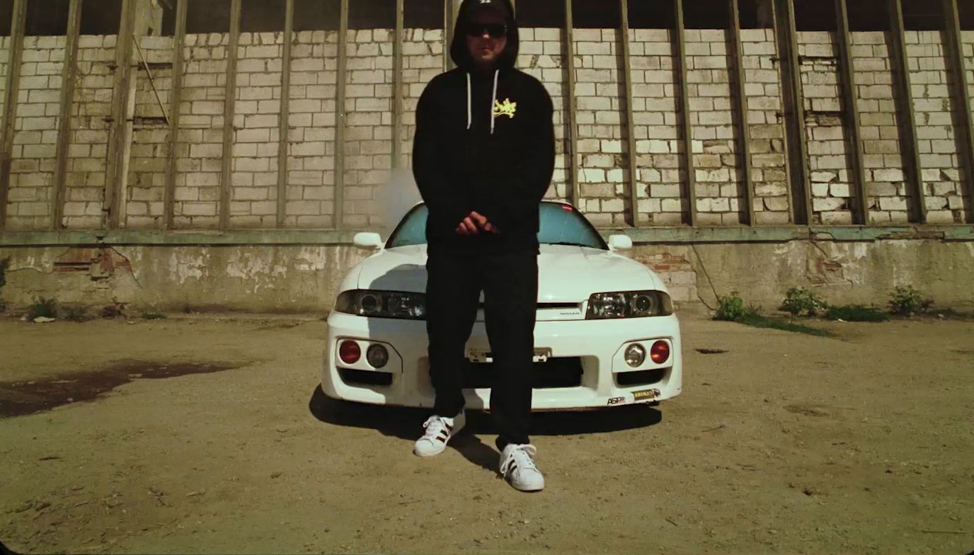 a man sitting on top of a white car