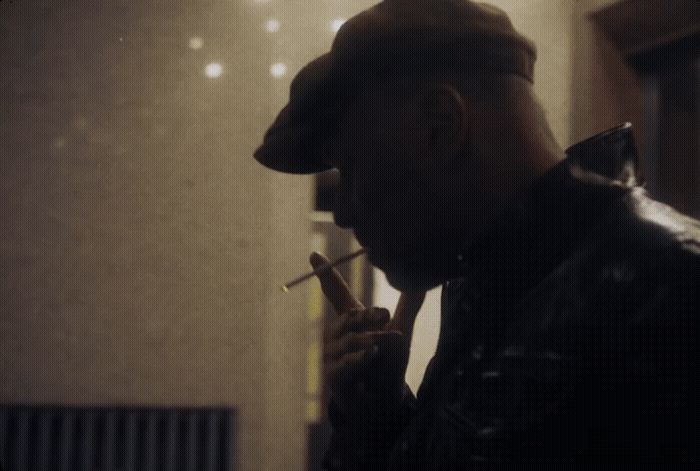 a man in a hat smoking a cigarette