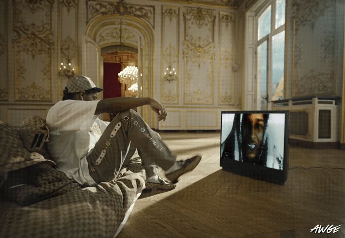 a man sitting on a couch watching a tv