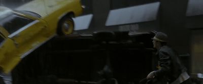 a man standing next to a yellow car in a garage