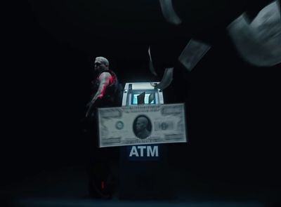 a man standing in front of a box with a dollar bill in it