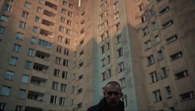 a man standing in front of tall buildings