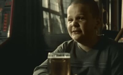 a man sitting at a table with a glass of beer