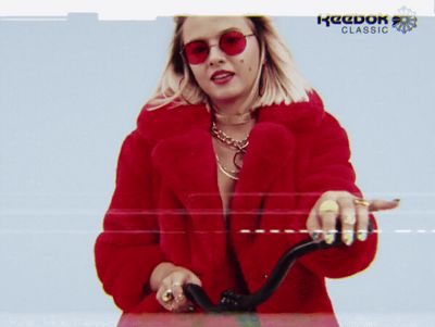 a woman in a red coat is riding a bike