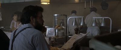 a man standing in front of a counter in a kitchen