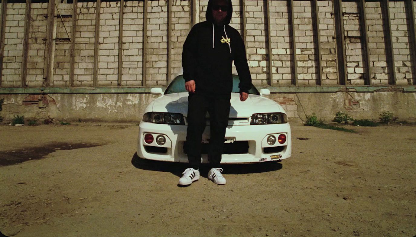 a man standing next to a white sports car