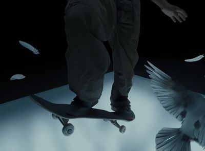 a man riding a skateboard next to a bird