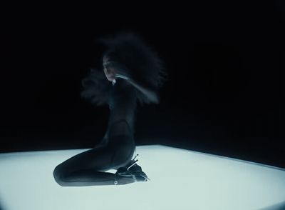 a woman sitting on the floor in the dark