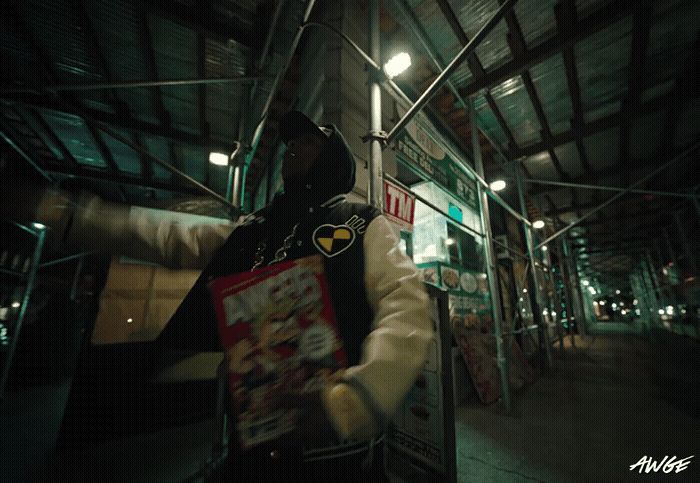 a man in a black and white jacket holding a bag