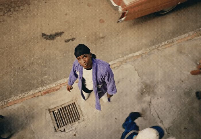 a person standing on a sidewalk with a car in the background