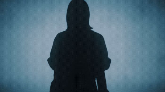 a silhouette of a person standing in the dark