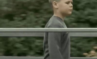 a young boy standing on top of a metal rail