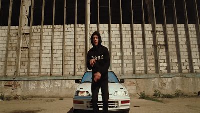 a man sitting on the hood of a car